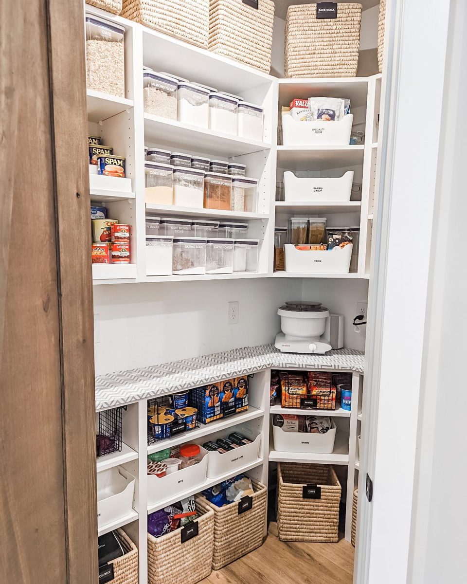 Walk-in pantry organized with labeled baskets and clear canisters