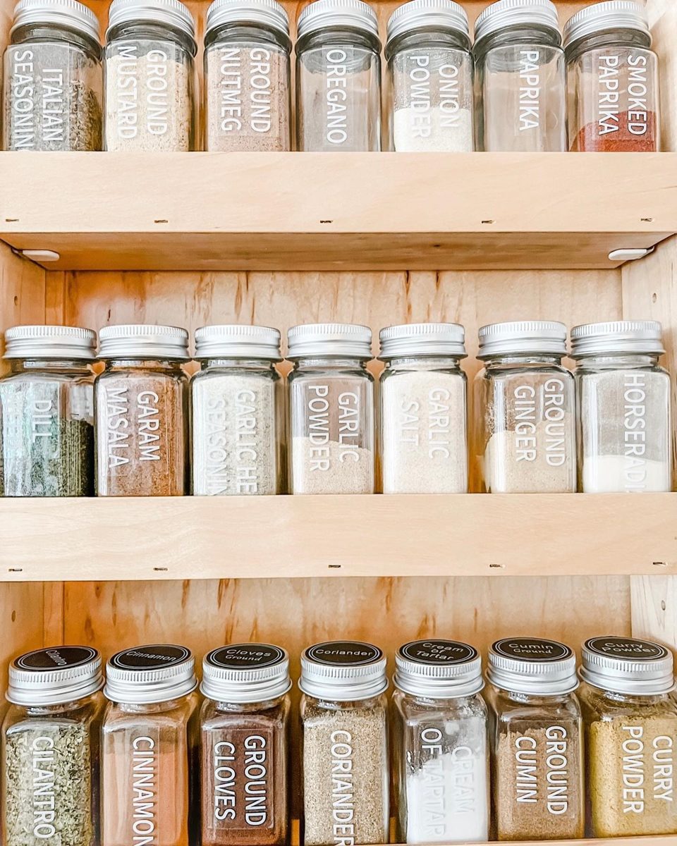 Wood spice rack with decanted, labeled spice jars