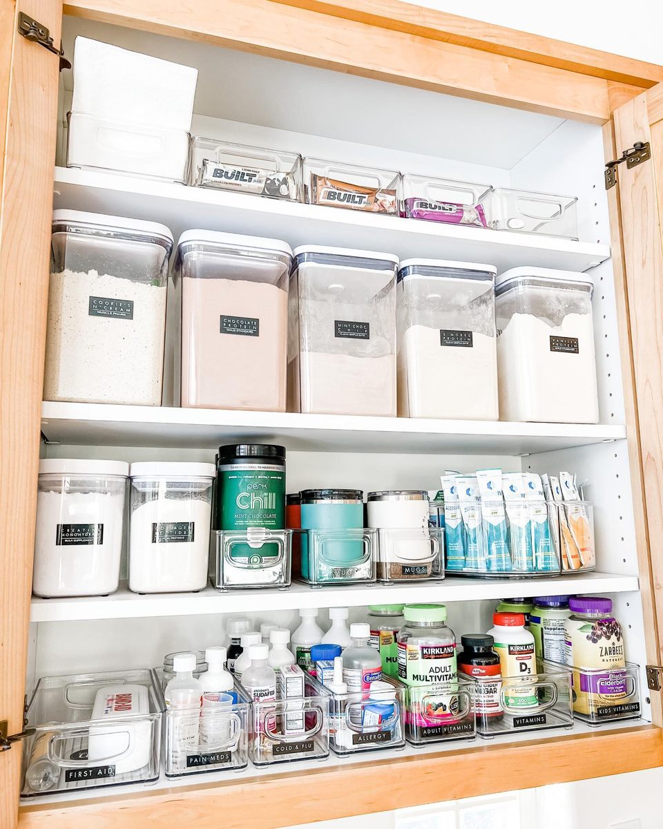Cabinet with labeled bins for medicine, vitamins, and protein powders