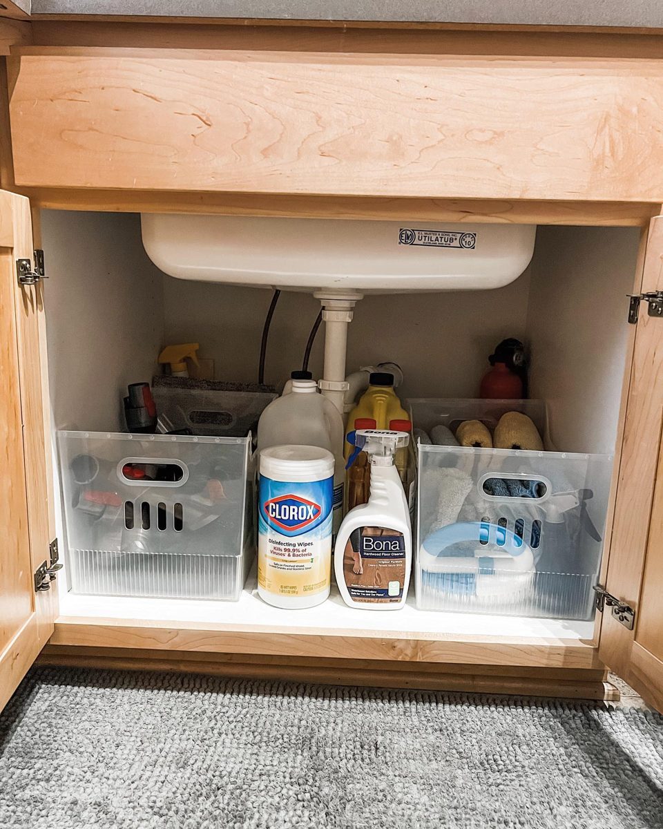 Under-sink cabinet with clear bins for cleaning supplies